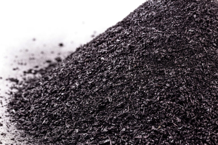 A close-up of a pile of crushed charcoal pieces on a white background