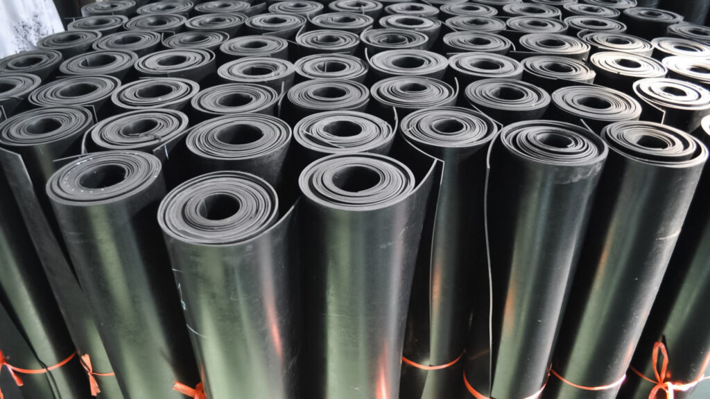 Rolled industrial black rubber sheets arranged in stacks